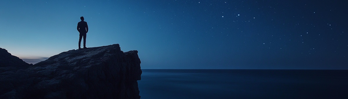 ws-graemev_13195_a_man_standing_on_a_cliff_at_night_looking_out_ac_b209ae57-7c54-4119-a05e-a5005a7b13ed